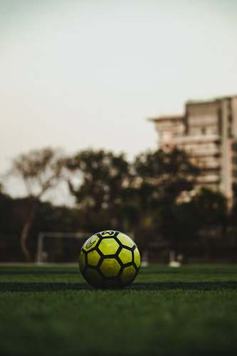 team sport yellow and black soccer ball on field during daytime ball